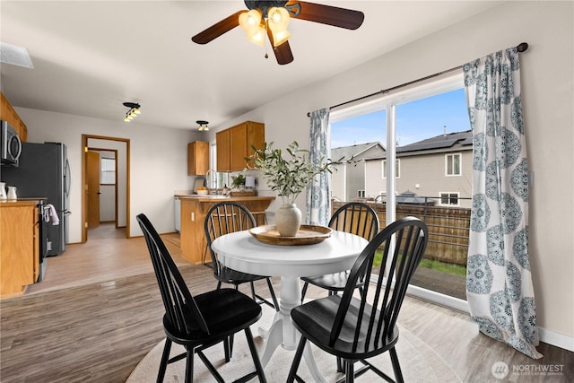 dining room with visible vents, baseboards, light wood-style flooring, and a ceiling fan