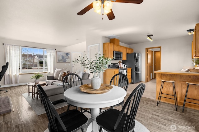 dining area with light wood-style flooring and ceiling fan