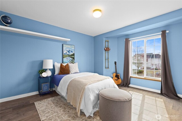 bedroom with baseboards and wood finished floors