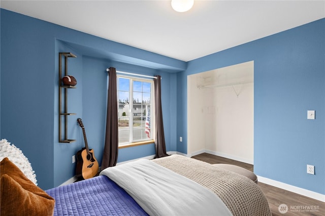 bedroom featuring a closet, baseboards, and wood finished floors