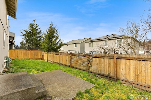 view of yard featuring a residential view, a fenced backyard, and a patio area