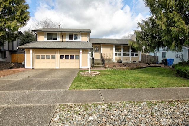 split level home with an attached garage, a shingled roof, fence, a front yard, and driveway