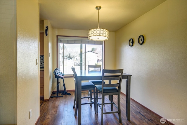 dining room featuring baseboards and dark wood-style flooring