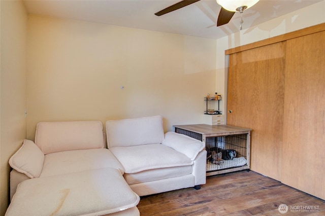 sitting room with a ceiling fan and wood finished floors