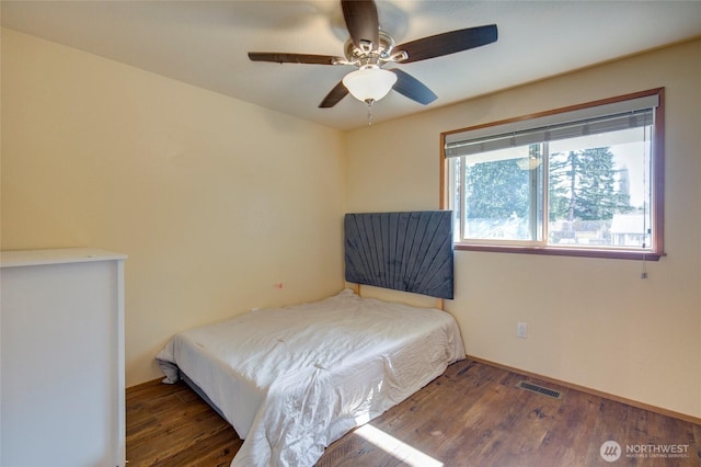 bedroom featuring a ceiling fan, wood finished floors, and visible vents