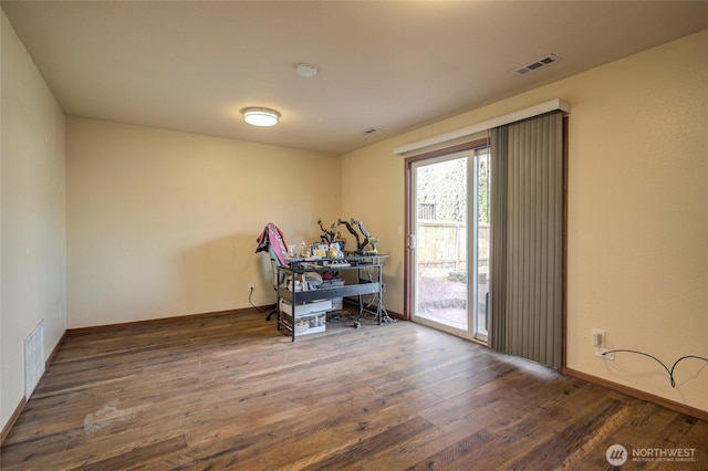 interior space featuring baseboards, visible vents, and wood-type flooring