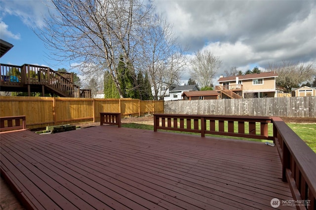 wooden terrace with a fenced backyard