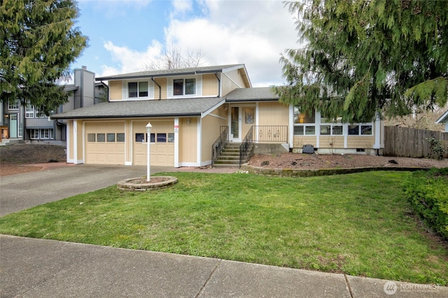 tri-level home with aphalt driveway, fence, roof with shingles, a front yard, and a garage