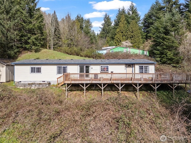 back of house featuring crawl space and a deck