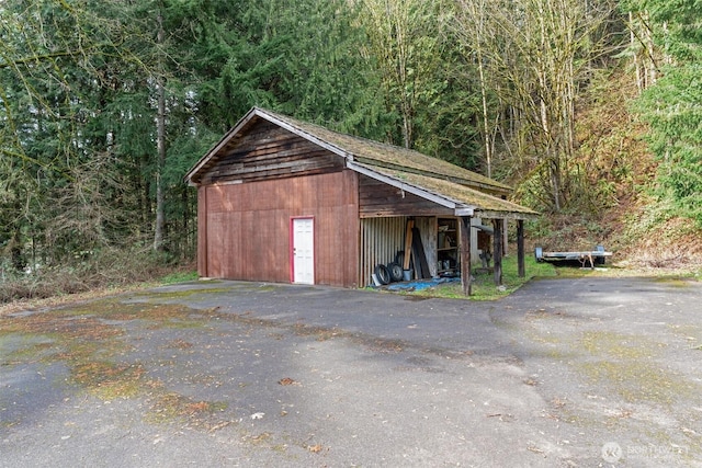 view of outbuilding featuring an outbuilding and a view of trees