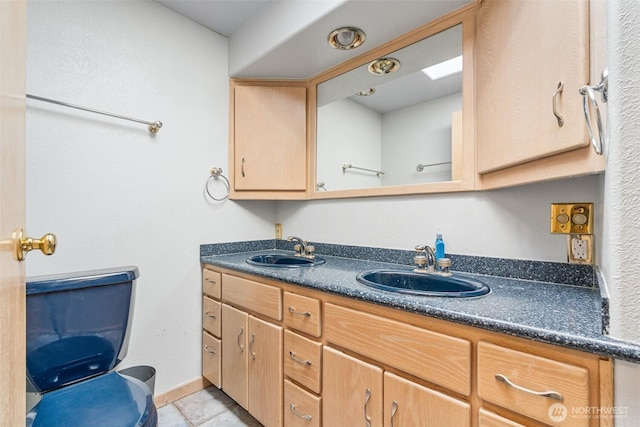 full bath featuring a sink, baseboards, double vanity, and tile patterned floors