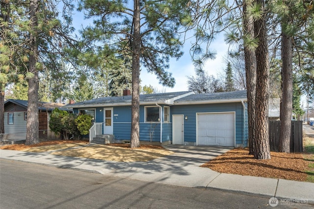 ranch-style home with a garage, a chimney, and driveway