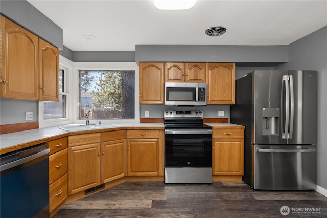 kitchen featuring a sink, stainless steel appliances, visible vents, and light countertops