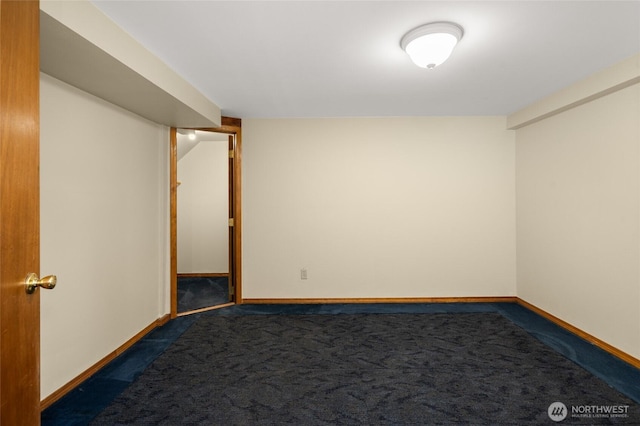 empty room with baseboards and dark colored carpet