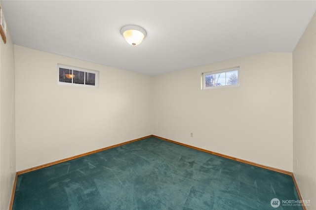 basement with baseboards and dark carpet