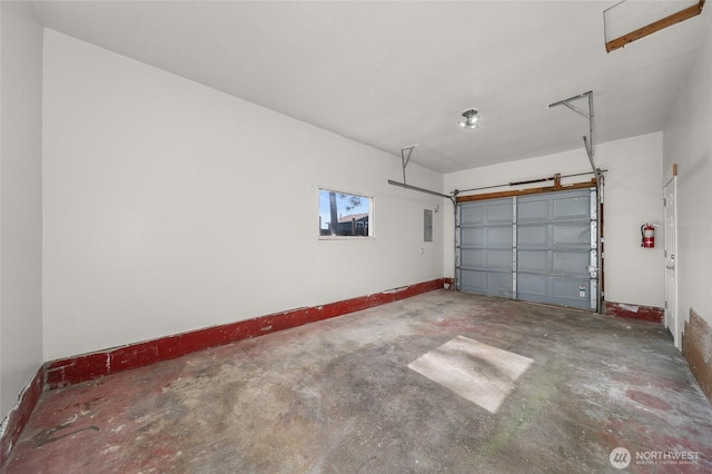 garage featuring electric panel and baseboards