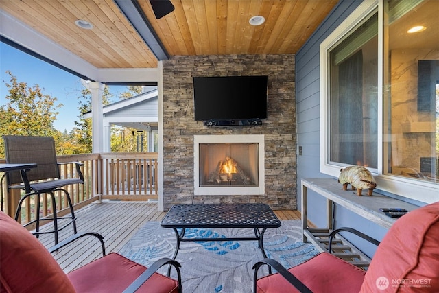 view of patio featuring a wooden deck and an outdoor stone fireplace