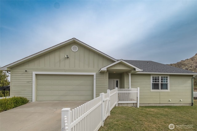 ranch-style house featuring driveway, fence, roof with shingles, a front yard, and an attached garage