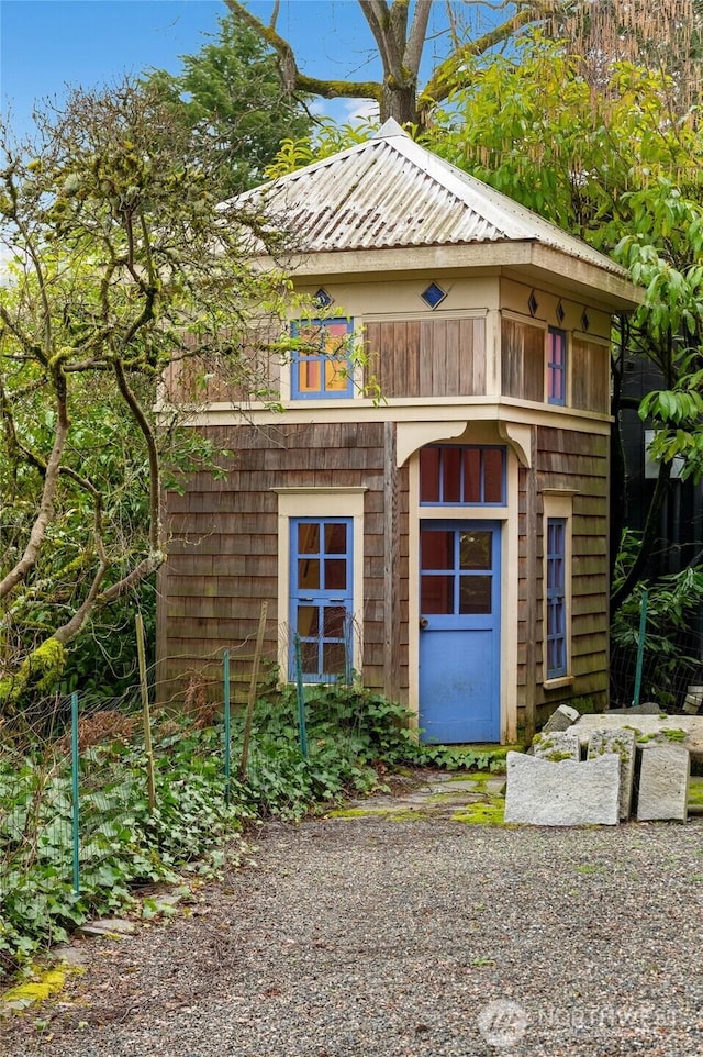 view of front of property with an outbuilding and metal roof