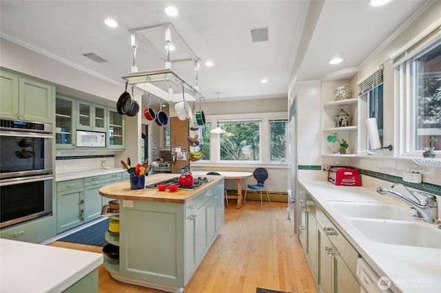 kitchen featuring open shelves, stainless steel appliances, and green cabinetry