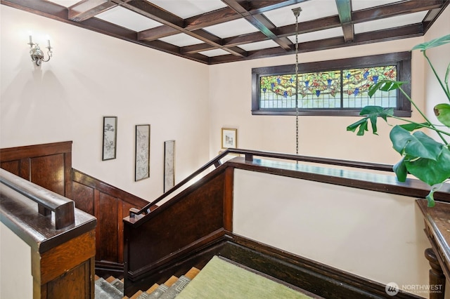 stairs featuring beamed ceiling and coffered ceiling