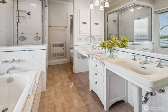 bathroom with a garden tub, ornamental molding, a sink, a tile shower, and tile patterned flooring