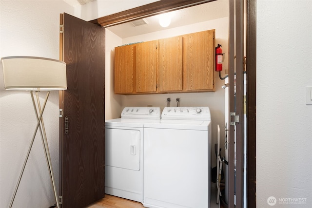 laundry area featuring washer and dryer and cabinet space