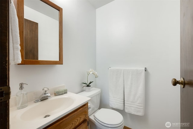 half bathroom with vanity and toilet