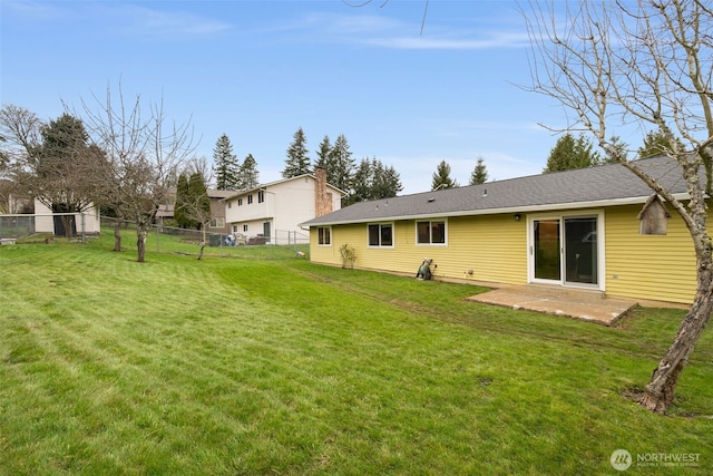 rear view of house featuring a patio, a yard, and fence