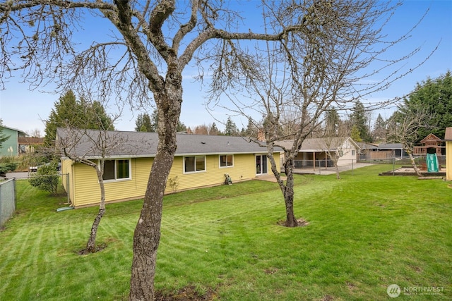 view of yard featuring a patio area, a playground, and a fenced backyard