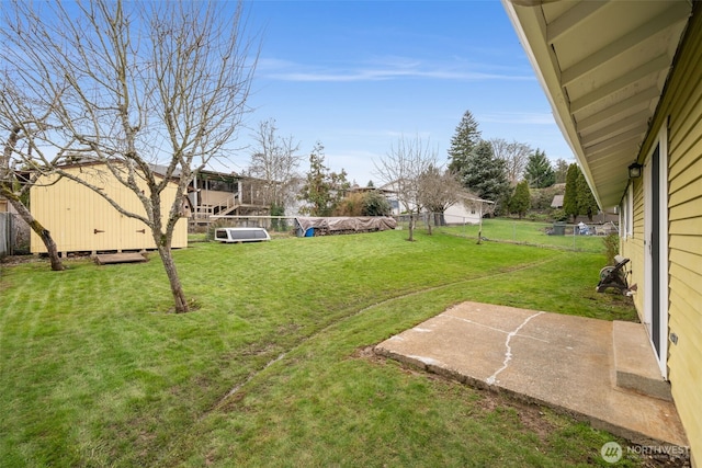 view of yard with a storage unit, an outdoor structure, and fence