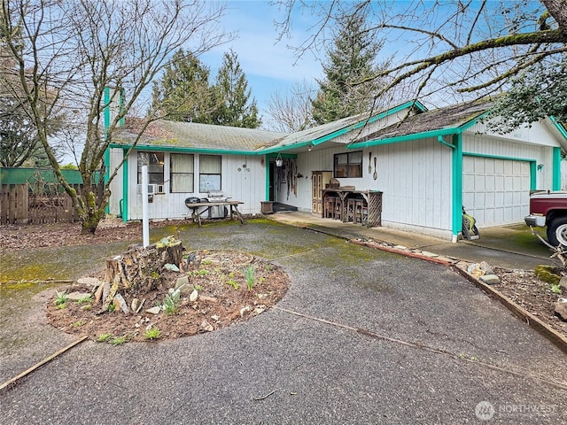 single story home with fence, a garage, and driveway