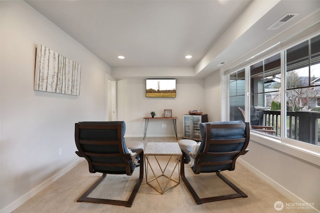 living area with baseboards, visible vents, and carpet floors