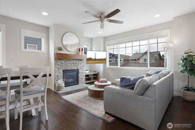 living area featuring a ceiling fan, baseboards, dark wood finished floors, recessed lighting, and a fireplace