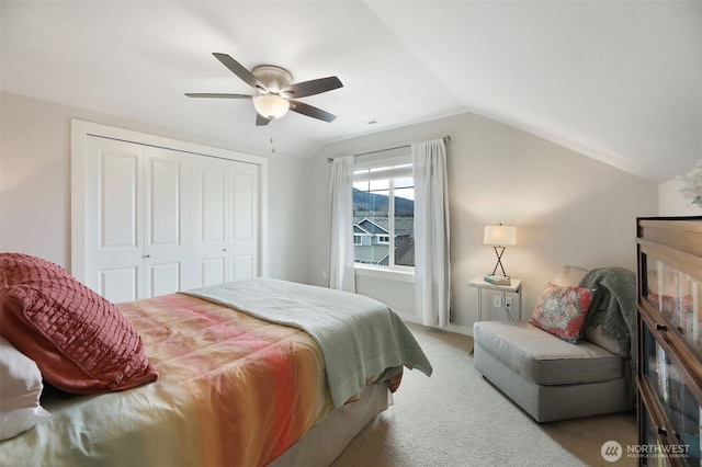 bedroom with vaulted ceiling, a ceiling fan, a closet, and carpet floors