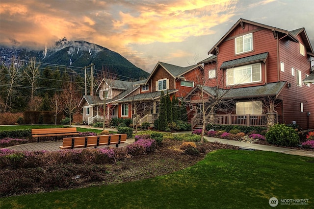 view of front facade featuring a front lawn, a porch, and a mountain view