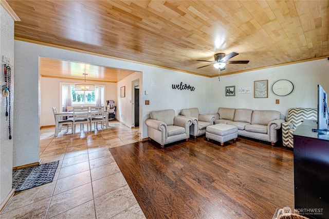 living area featuring wooden ceiling, a ceiling fan, and ornamental molding