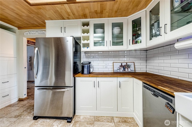 kitchen with wood ceiling, backsplash, butcher block countertops, and appliances with stainless steel finishes