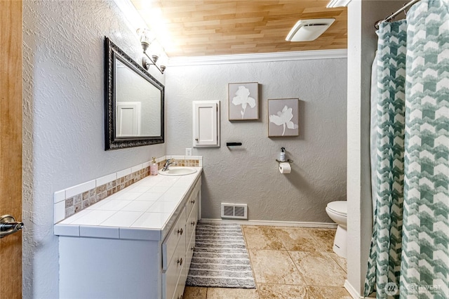 full bathroom featuring visible vents, baseboards, toilet, a textured wall, and vanity