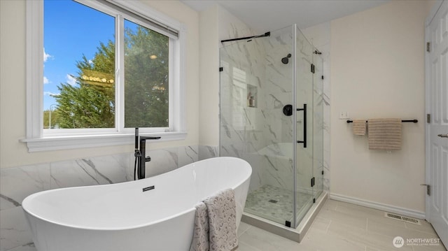 full bathroom with a marble finish shower, visible vents, and a freestanding bath