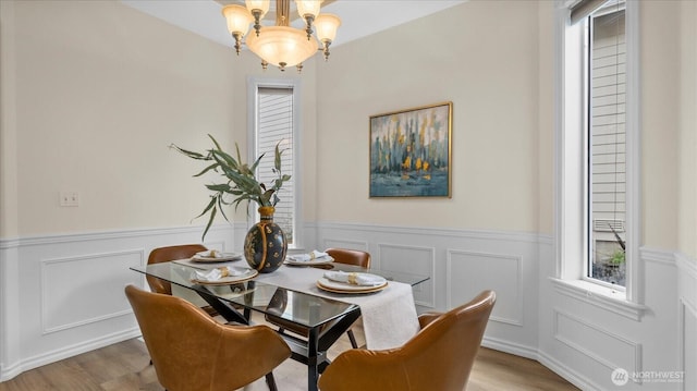 dining room with a chandelier, a healthy amount of sunlight, and light wood-style flooring