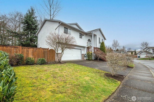 view of side of property featuring aphalt driveway, fence, a garage, and a lawn