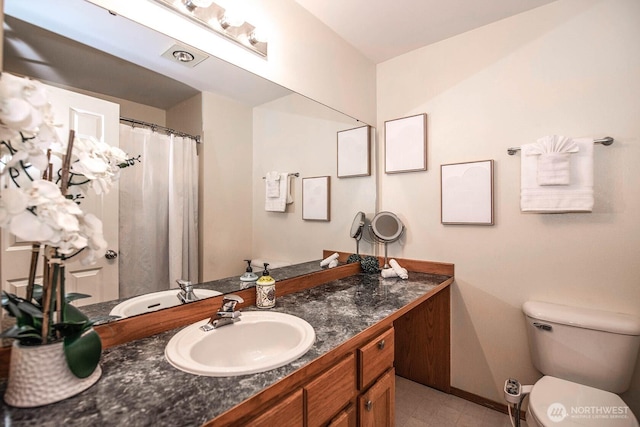 bathroom with vanity, toilet, and baseboards