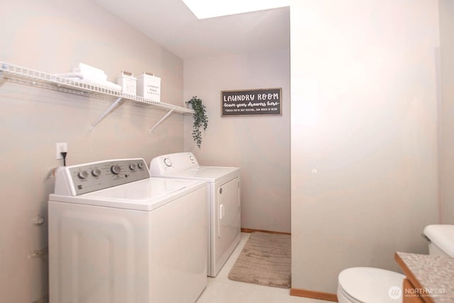 laundry room with baseboards, a skylight, laundry area, and washer and clothes dryer