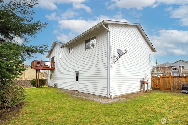 view of side of home featuring a lawn, a fenced backyard, and a wooden deck