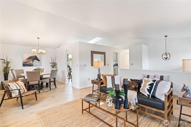 living room with vaulted ceiling, baseboards, light wood-type flooring, and a chandelier