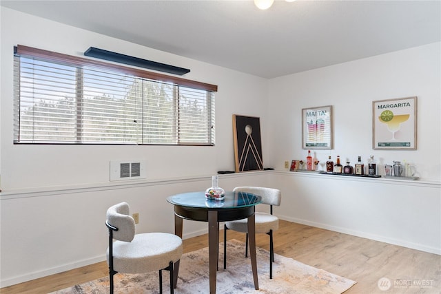 dining room with visible vents, baseboards, and light wood-style floors