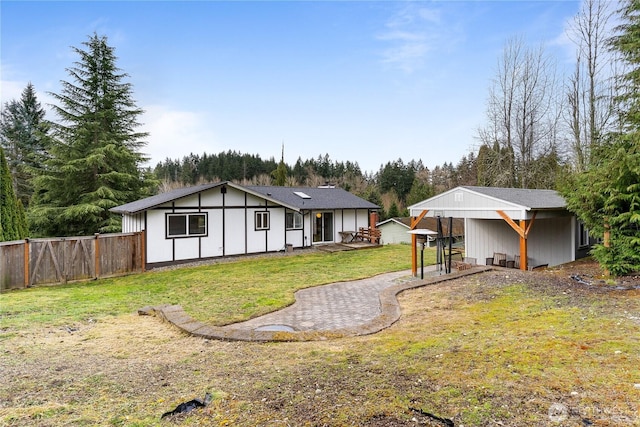 rear view of house featuring a yard and fence