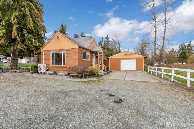 view of front of property featuring a detached garage, fence, ac unit, an outbuilding, and driveway