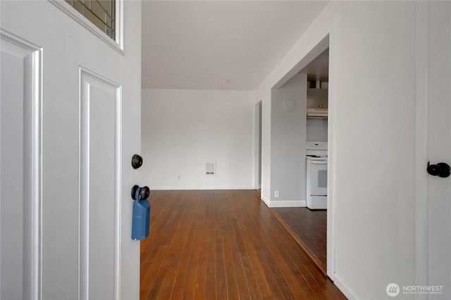 hall featuring visible vents, wood-type flooring, and baseboards